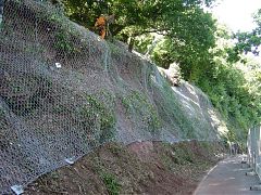 Rock fall netting and anchors to slope